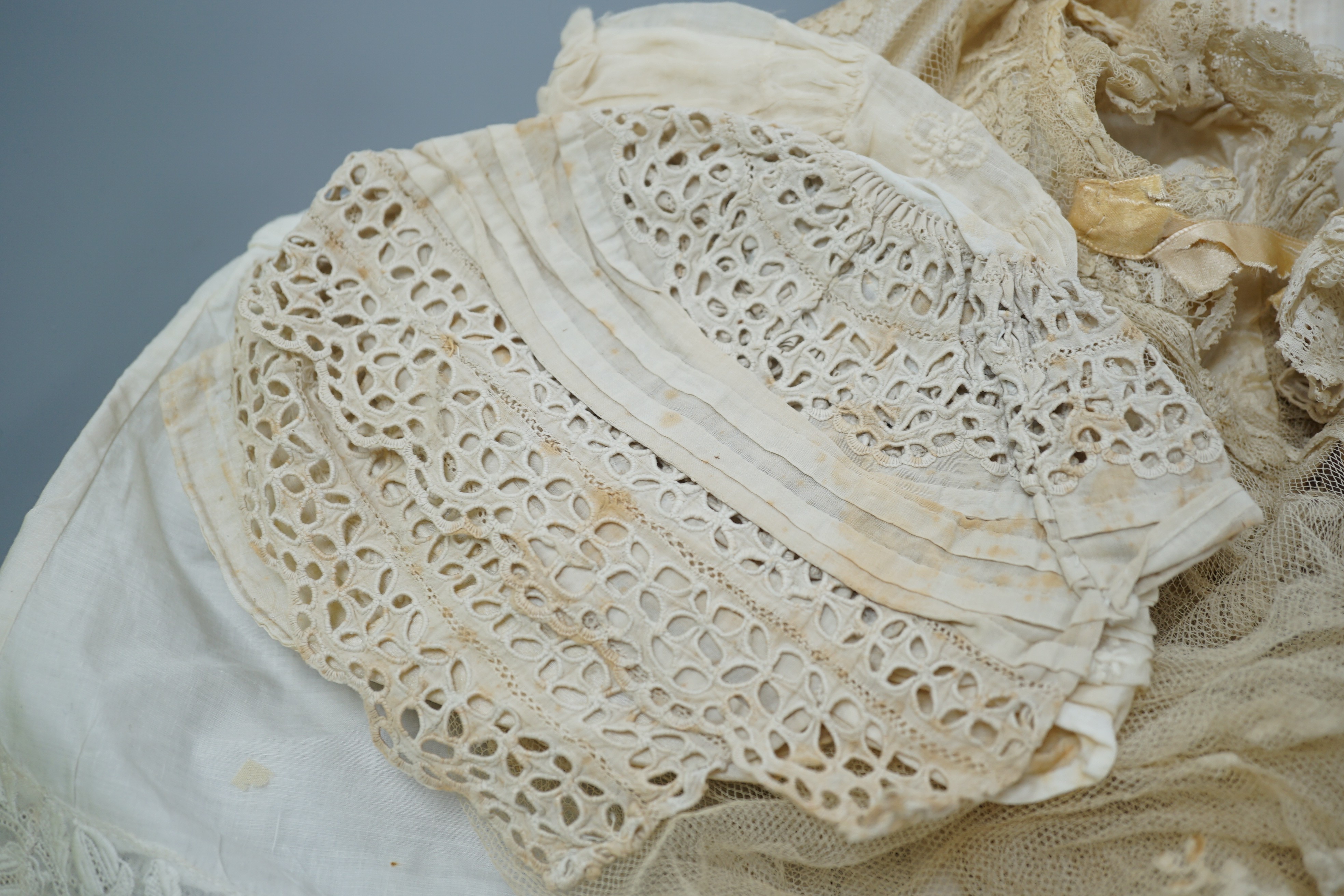 A collection of 19th century babywear, lace and cutwork bonnets and a christening bonnet and veil